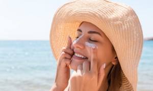 woman applying sunscreen at the beach