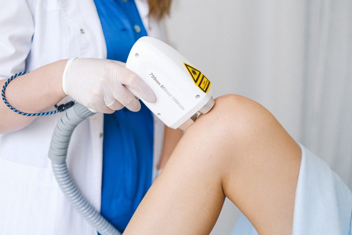 A woman getting laser hair treatment on her leg.