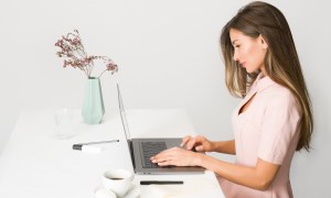 woman-in-pink-dress-sitting-at-white-desk