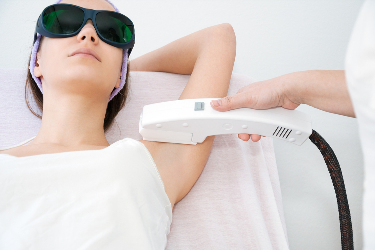 A woman getting laser hair removal on her underarms.