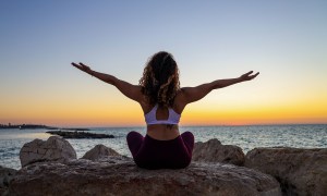 Relaxed woman doing yoga by the ocean